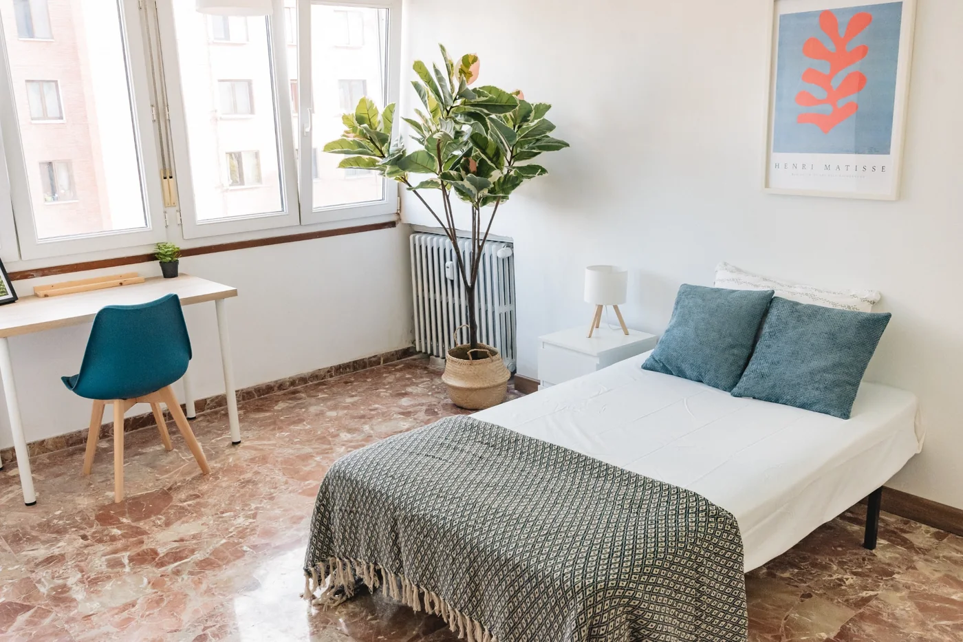 Habitación doble con escritorio, planta y luz natural